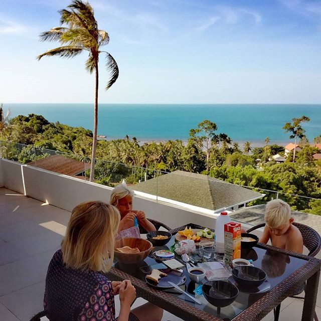 Family enjoying breakfast on a sea-view balcony
